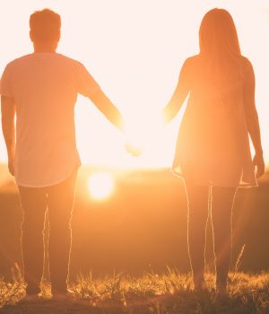 pareja tomada de las manos en una atardecer