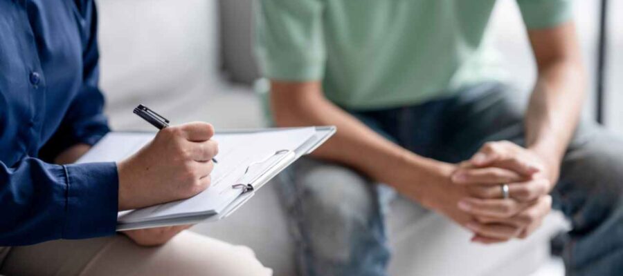 Psicologa anotando al lado una persona con remera verde